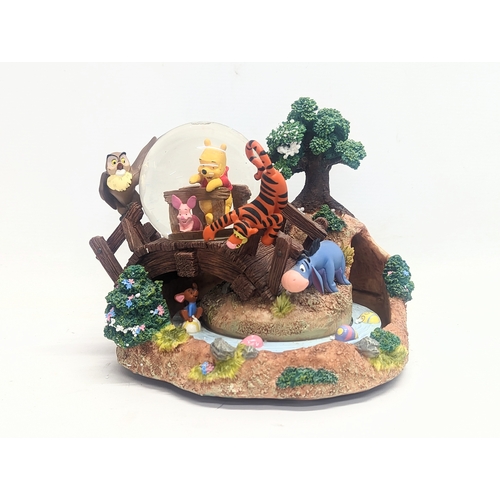 694 - A Walt Disney Winnie-the-Pooh and friends snow globe. 18cm