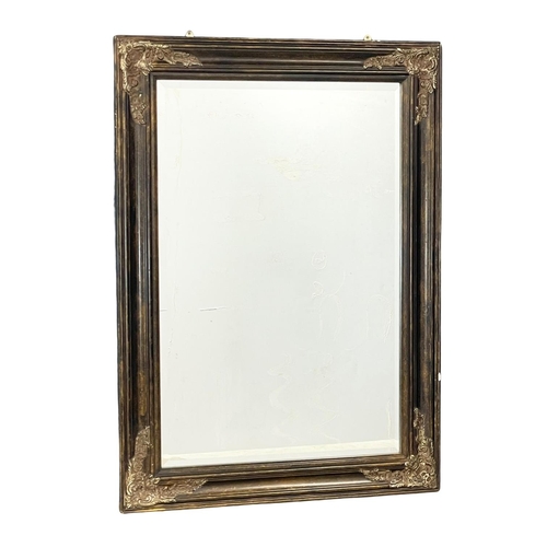 235F - A large ornate gilt framed bevelled mirror. 79x119cm