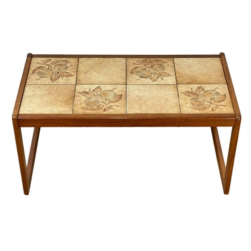 895 - A Mid Century teak coffee table, with tile top. 85x48x40cm