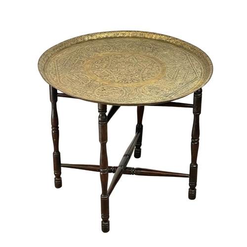 902 - A late 19th century Islamic brass top folding table. 60x54cm