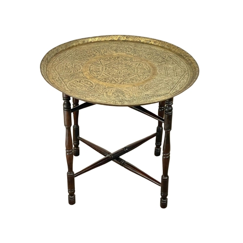 902 - A late 19th century Islamic brass top folding table. 60x54cm