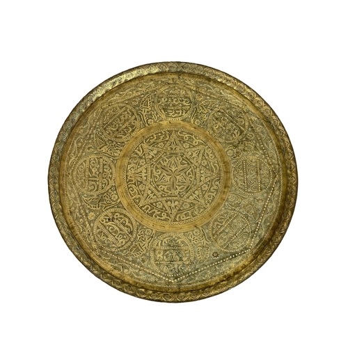 902 - A late 19th century Islamic brass top folding table. 60x54cm