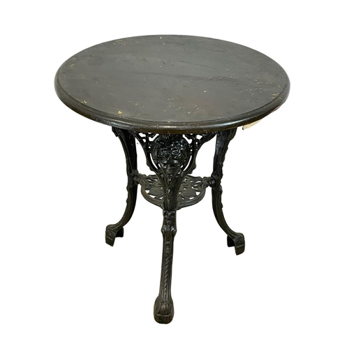 911 - A vintage cast iron base garden table. 68x70cm