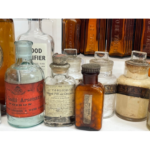 71 - A collection of early 20th century chemist bottles. Largest 23cm.