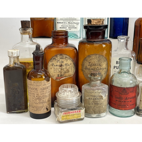 71 - A collection of early 20th century chemist bottles. Largest 23cm.