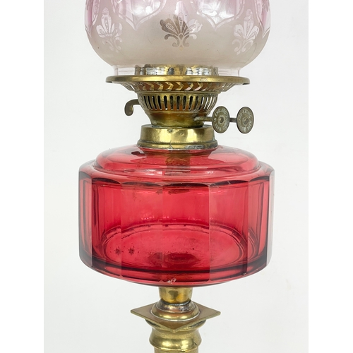 21 - A large Victorian Ruby Glass and brass double burner oil lamp. 72cm