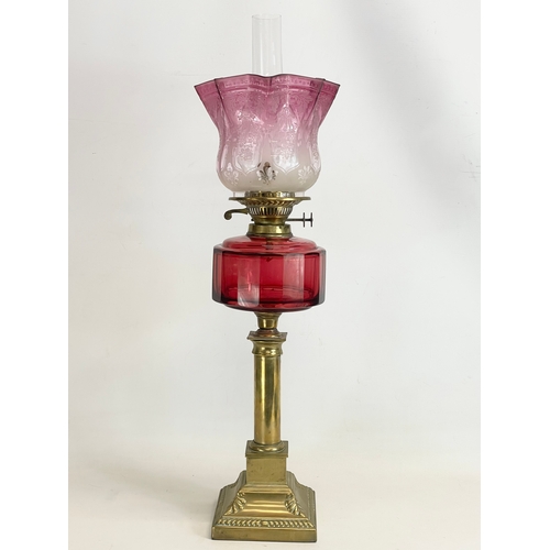 21 - A large Victorian Ruby Glass and brass double burner oil lamp. 72cm