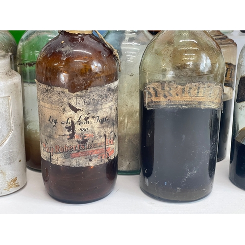 75 - A collection of early 20th century chemist bottles. Largest 32cm. 24cm