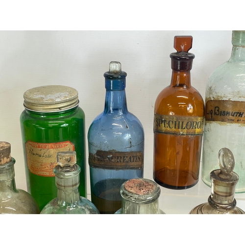 75 - A collection of early 20th century chemist bottles. Largest 32cm. 24cm