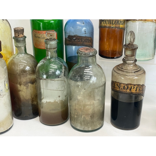 75 - A collection of early 20th century chemist bottles. Largest 32cm. 24cm