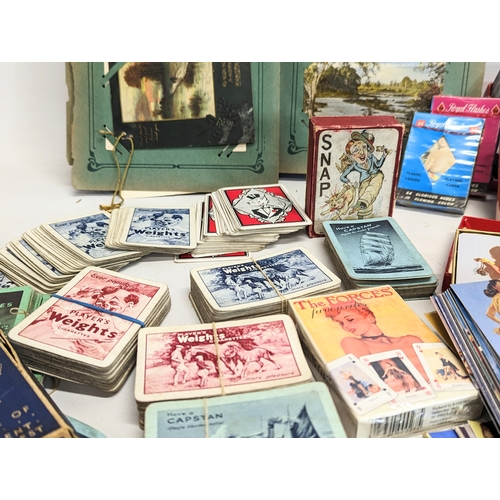 225 - A collection of vintage playing cards, postcards in album, vintage Pinup Girl cards, novelty postcar... 