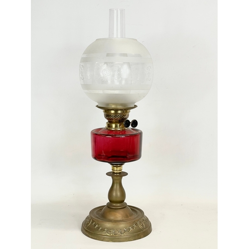 29 - A Victorian Ruby Glass and brass double burner oil lamp. 60cm