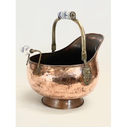 34 - A vintage copper coal scuttle with pottery handles. 31x36x29cm not including handle.