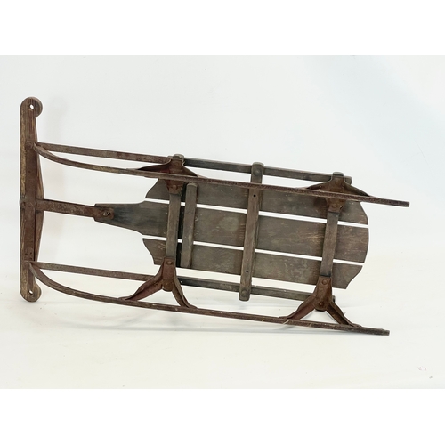 85 - An early 20th century wood and metal child’s sleigh. 82cm