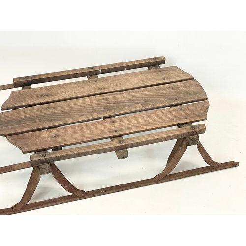 85 - An early 20th century wood and metal child’s sleigh. 82cm