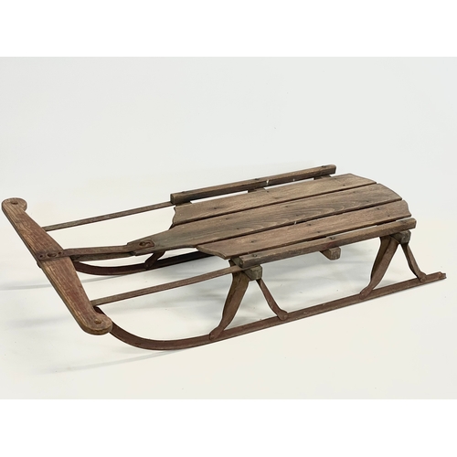 85 - An early 20th century wood and metal child’s sleigh. 82cm