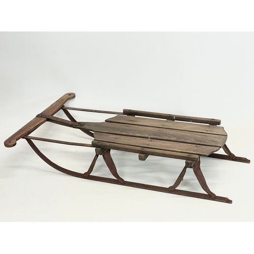 85 - An early 20th century wood and metal child’s sleigh. 82cm