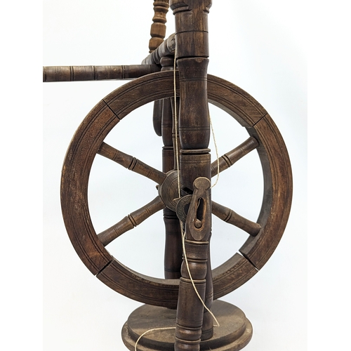 345 - A vintage spinning wheel. 96cm