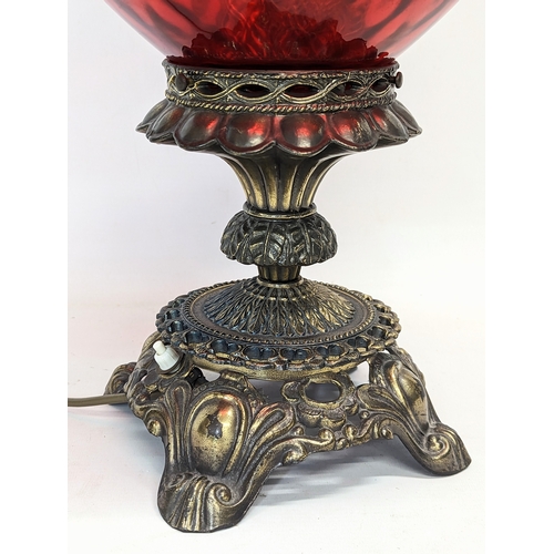 293 - A vintage ruby glass and brass paraffin lamp. 61cm