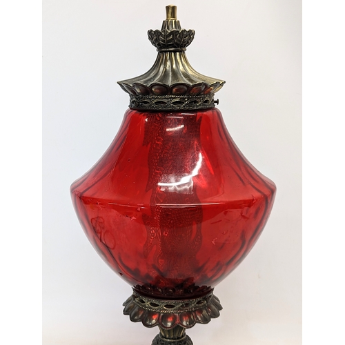 293 - A vintage ruby glass and brass paraffin lamp. 61cm