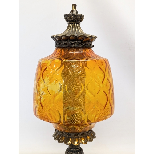 291 - A vintage ornate amber glass and brass paraffin lamp. 62cm