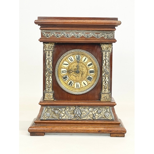 163 - A late 19th century mahogany and brass cased mantle clock with cherub and enamel face. 24x11x30cm