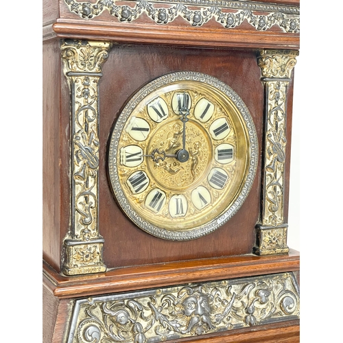 163 - A late 19th century mahogany and brass cased mantle clock with cherub and enamel face. 24x11x30cm