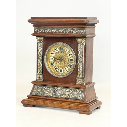 163 - A late 19th century mahogany and brass cased mantle clock with cherub and enamel face. 24x11x30cm