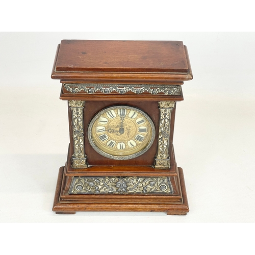 163 - A late 19th century mahogany and brass cased mantle clock with cherub and enamel face. 24x11x30cm