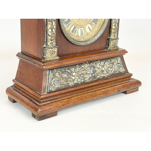 163 - A late 19th century mahogany and brass cased mantle clock with cherub and enamel face. 24x11x30cm