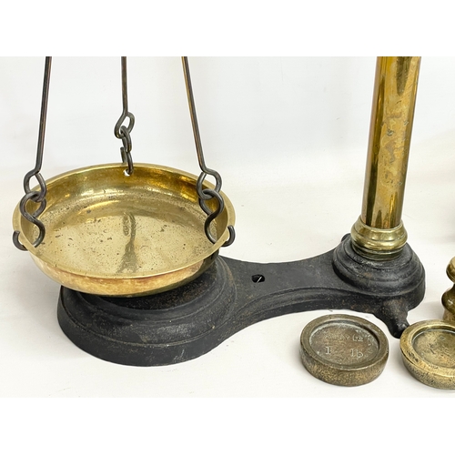 159 - A set of large Victorian brass and cast iron Class B balance scales with weights. 65x83cm