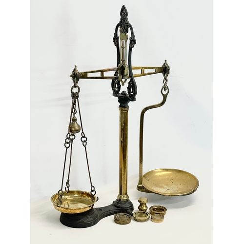 159 - A set of large Victorian brass and cast iron Class B balance scales with weights. 65x83cm