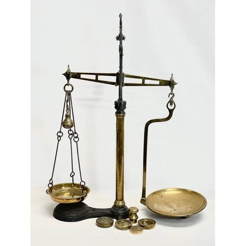 159 - A set of large Victorian brass and cast iron Class B balance scales with weights. 65x83cm