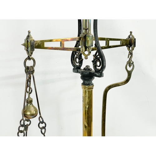 159 - A set of large Victorian brass and cast iron Class B balance scales with weights. 65x83cm