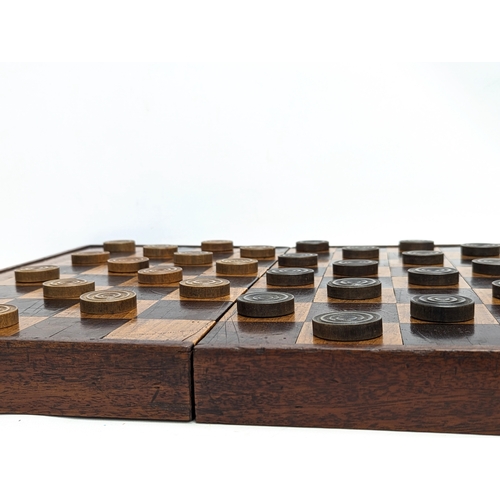 165 - An early 20th century mahogany draughts board with pieces. Board measures 51.5x45.5cm