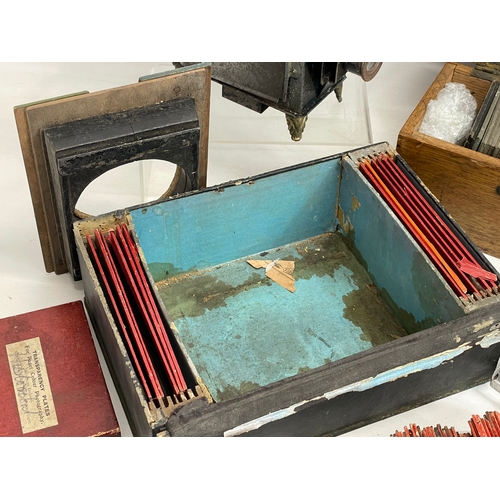 102 - A collection of early 20th century camera lantern plates and The Standard Magic Lantern in box.