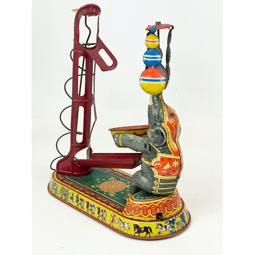 249 - A 1950’s West German tin plate wind up toy. Elephant juggling. 23x24cm