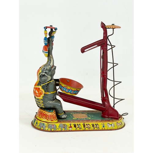 249 - A 1950’s West German tin plate wind up toy. Elephant juggling. 23x24cm