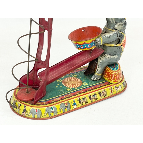 249 - A 1950’s West German tin plate wind up toy. Elephant juggling. 23x24cm