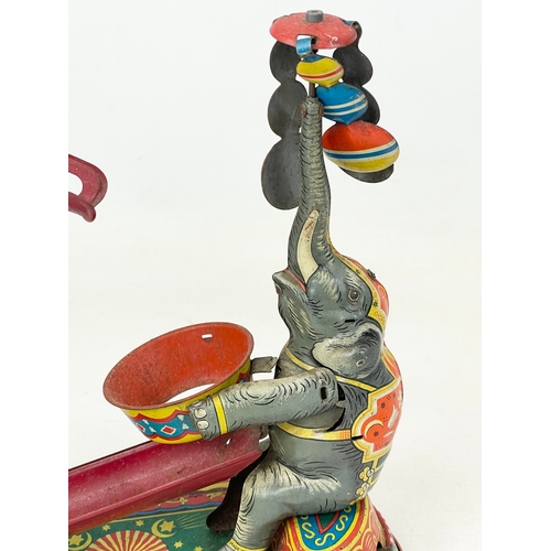 249 - A 1950’s West German tin plate wind up toy. Elephant juggling. 23x24cm