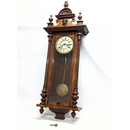 45 - A large Victorian mahogany Vienna wall clock with pendulum and key. 124cm