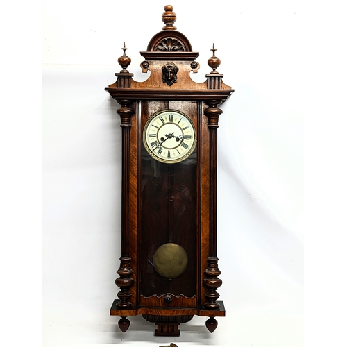 45 - A large Victorian mahogany Vienna wall clock with pendulum and key. 124cm