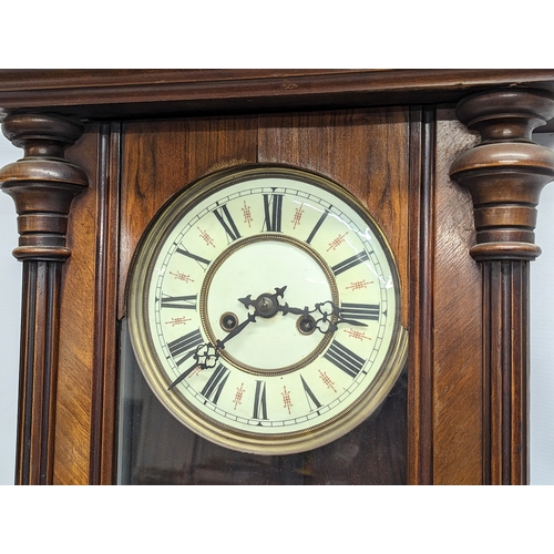 45 - A large Victorian mahogany Vienna wall clock with pendulum and key. 124cm