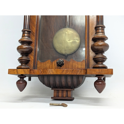 45 - A large Victorian mahogany Vienna wall clock with pendulum and key. 124cm