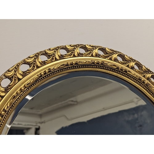 290E - An ornate gilt framed bevelled mirror. 48x86cm