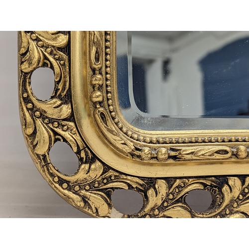 290E - An ornate gilt framed bevelled mirror. 48x86cm