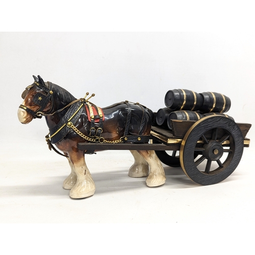 753 - A pottery Shire horse on wooden cart. 47x23cm