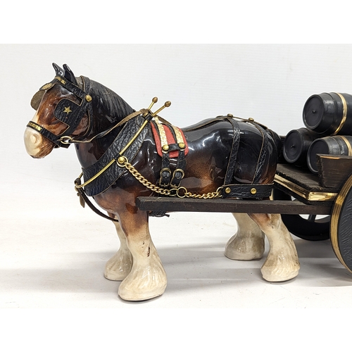 753 - A pottery Shire horse on wooden cart. 47x23cm