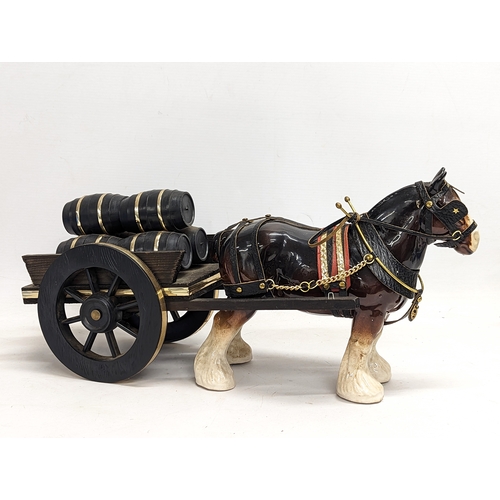 753 - A pottery Shire horse on wooden cart. 47x23cm