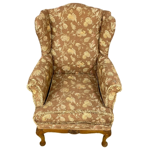 355 - A vintage wingback armchair.